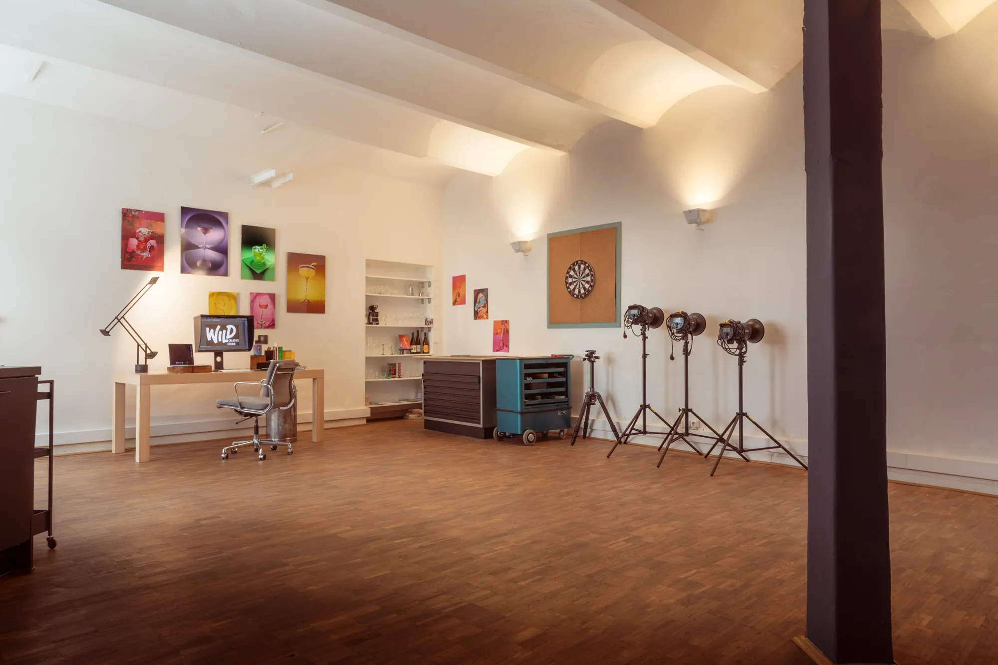 The Wild Creative Studio floor in Düsseldorf, drink prints along the white wall, desk and chair at one end and four strobes standing ready at the other