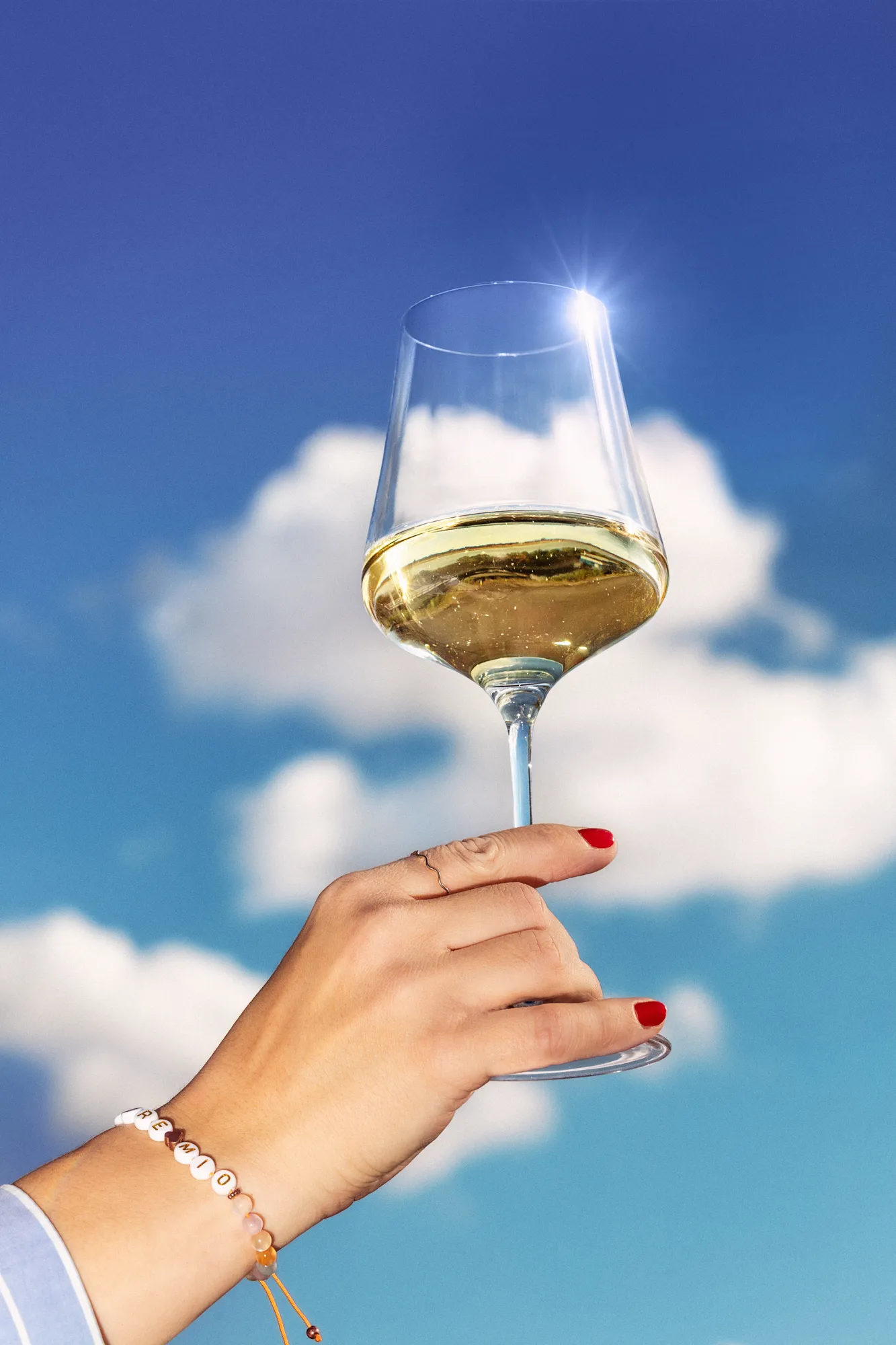 Wine glass raised against a blue sky